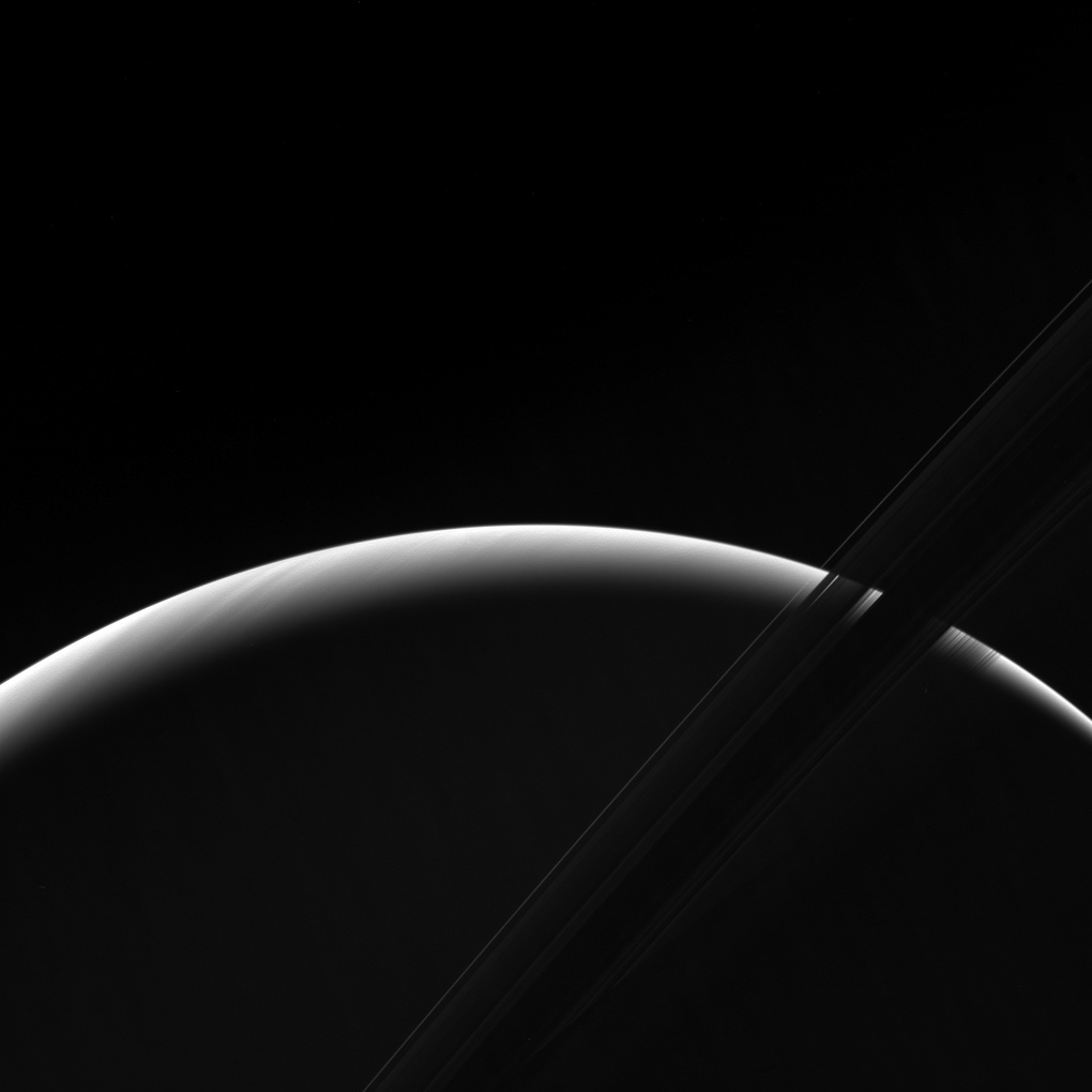 NASA's Cassini spacecraft peers toward a sliver of Saturn's sunlit atmosphere while the icy rings stretch across the foreground as a dark band.(NASA)